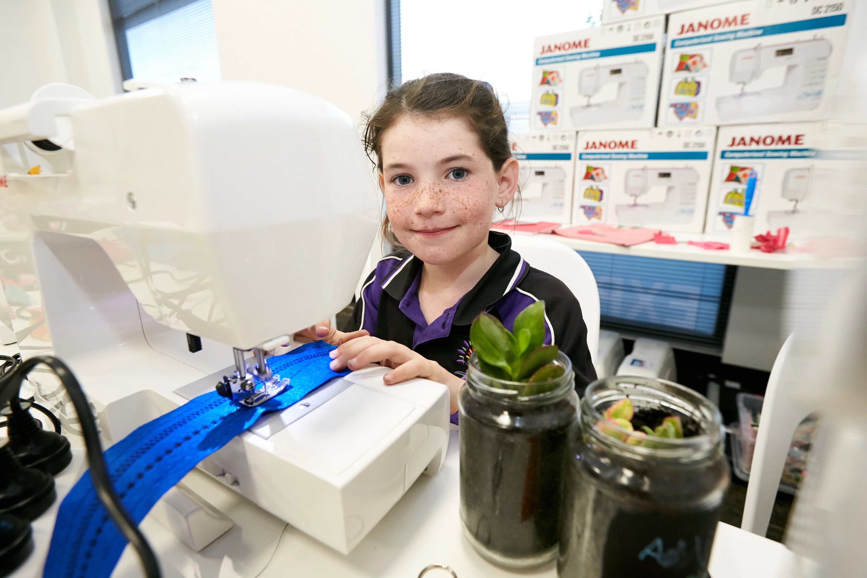 young person at sewing machine sewing.